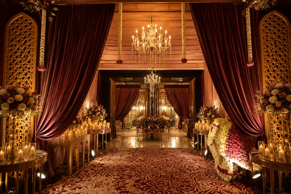 A candlelit entrance with velvet drapes, florals and crystal chandeliers, by Bluebird Events
