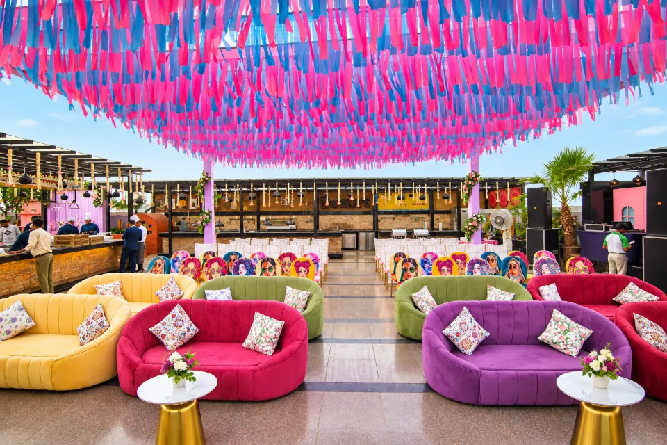 Colourful velvet sofas under a canopy of pink and blue ribbons at a mehendi decorated by Bluebird Events